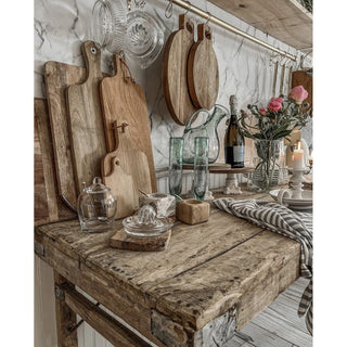 Reclaimed wood folding table in a farmhouse style kitchen with cutting boards and glasses